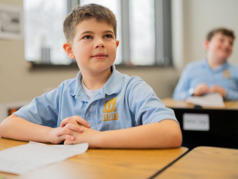 A Student Smiling from their Desk at Veritas Classical Academy by Mission by Design